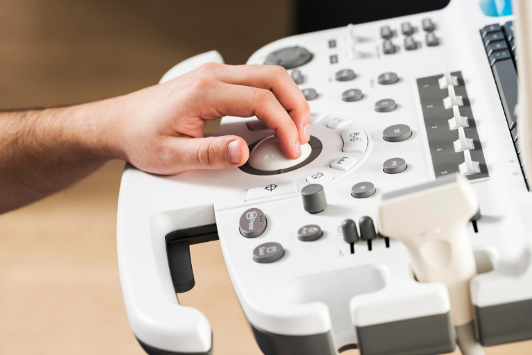 Nahaufnahme einer Hand auf der Bedienfläche eines Ultraschallgeräts.
